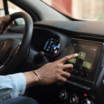 Conductor utilizando Apple CarPlay y Android Auto durante la conducción