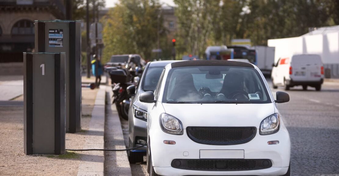 Coches eléctricos aparcados en la calle conectados a la corriente