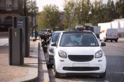 Coches eléctricos aparcados en la calle conectados a la corriente