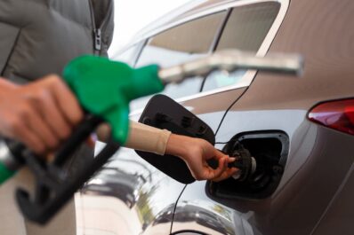 Persona llenando el tanque en una estación