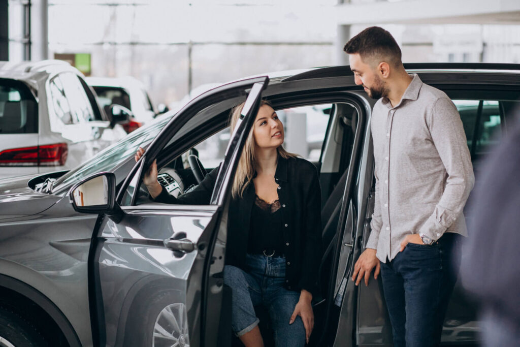 Una pareja conversando en un concesionario de coches