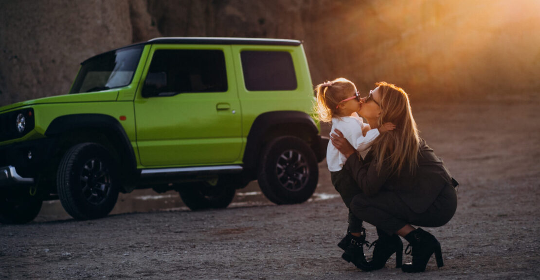 Una madres y su hija se abrazan cerca de su coche todoterreno