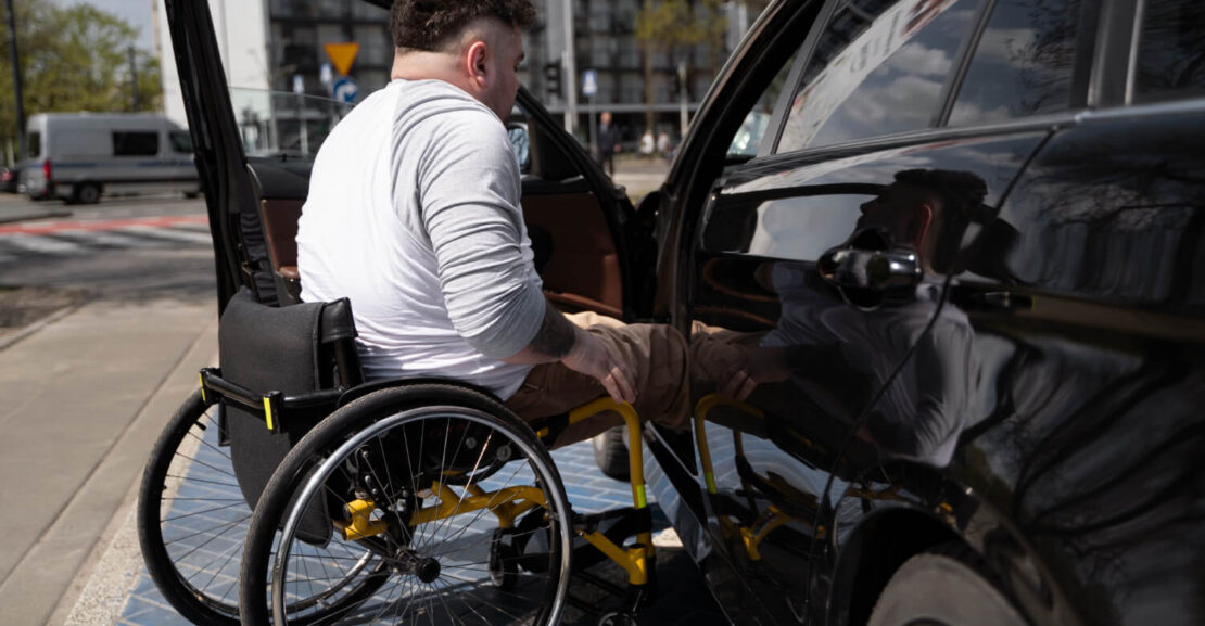 Una persona con movilidad reducir accede a su coche.