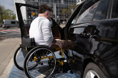 Una persona con movilidad reducir accede a su coche.