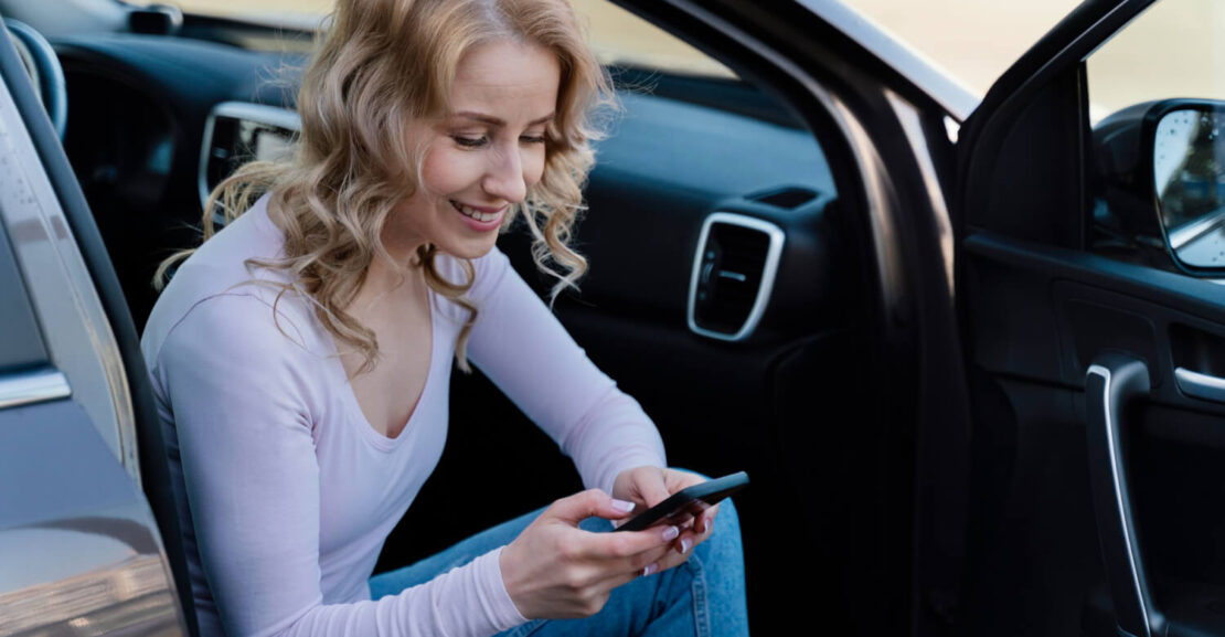 Una mujer mira el móvil en el coche