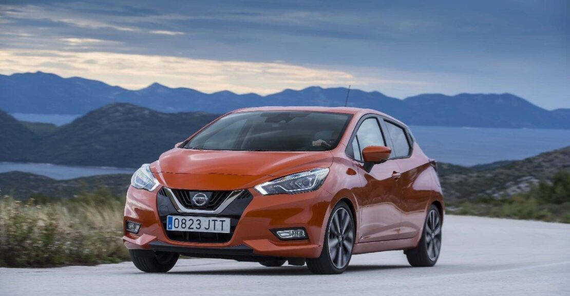 Nissan Micra de color naranja por la carretera