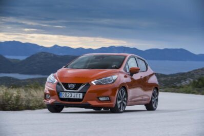 Nissan Micra de color naranja por la carretera